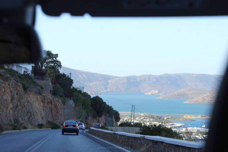 IMG_9475.JPG - As with all things , we must return to Elounda. Driving along the coast of Mirabello Bay,   Off in the distance is Spinolonga.  Thankfully,  we have always enjoyed the local taxi drivers.  