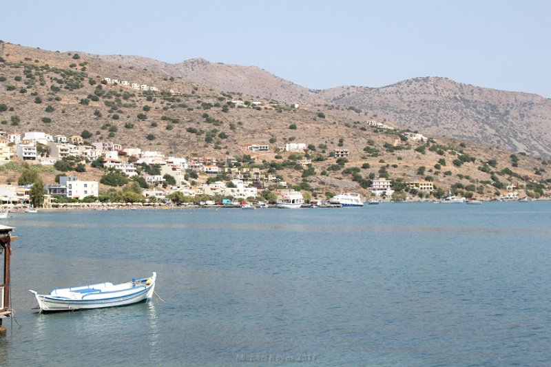IMG_8389.JPG - Looking toward Epano Elounda  up the hill. The walk from Elounda's harbour to Olous ancient town is a trip in memories for anyone who remembers "Who Pays the Ferryman", was a television series produced by the BBC in 1977? Now colorful bars-cafes and restaurants with terraces overlooking the sea, leads direct to the Ferryman taverna, where much of the action for the TV series was filmed.-----https://en.wikipedia.org/wiki/Who_Pays_the_Ferryman%3F